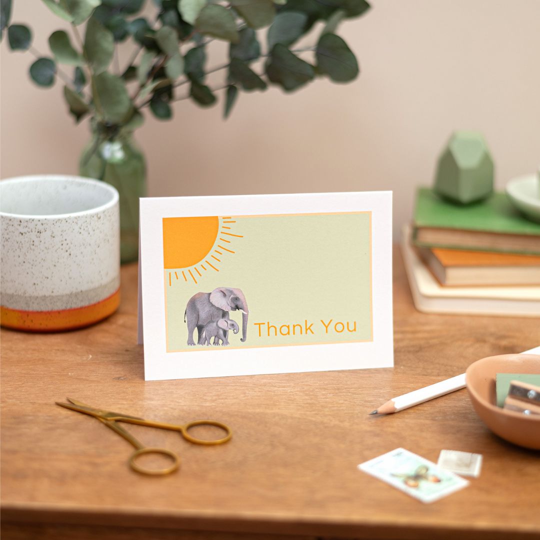 Thank You Cards. A6 Thank You Cards. Four Cards with have illustrations of a Kangaroo, bird, Kangaroo, flowers. The Cards are on a table, with a stack of books and stationery 