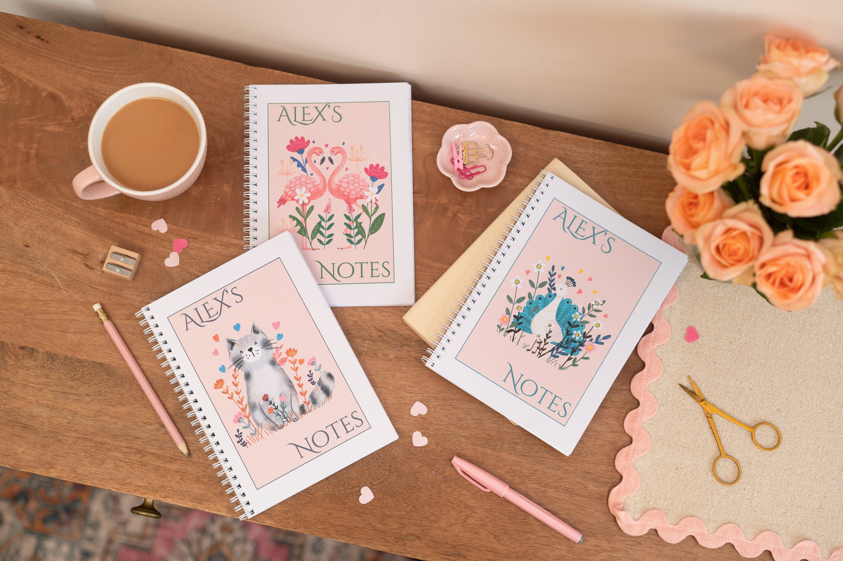 A5 Planner. A5 Planner with an illustration of two cartoons fox heads. The text on the planner says "Dream Big". The Planner is on a desk with flowers, a vase, tea and stationery