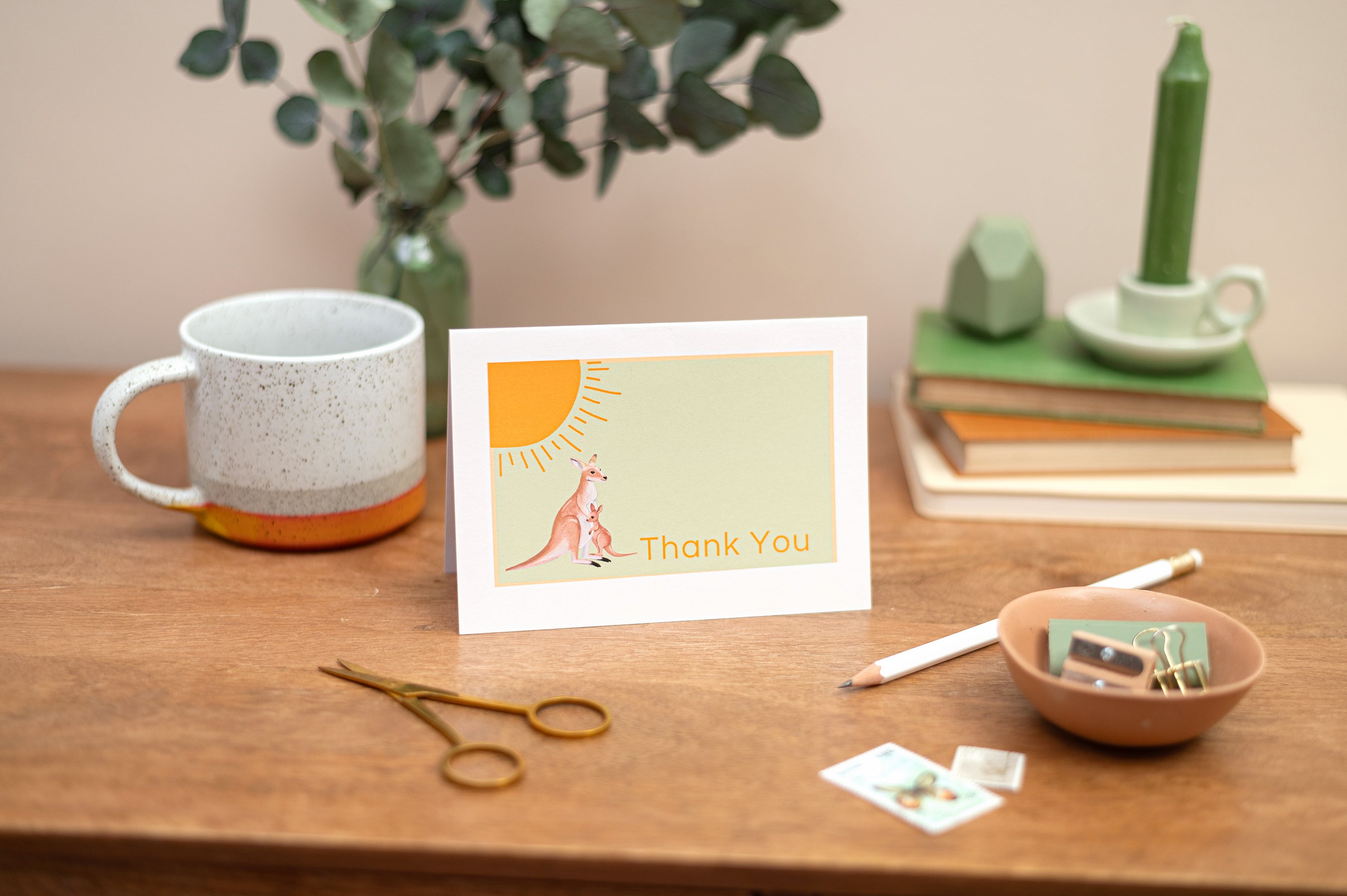 Blank and Everyday Cards. A6 Blank Card featuring a pair of pink flamingos facing each other with floral greenery surrounding them. The Card is on a table with flowers and stationery