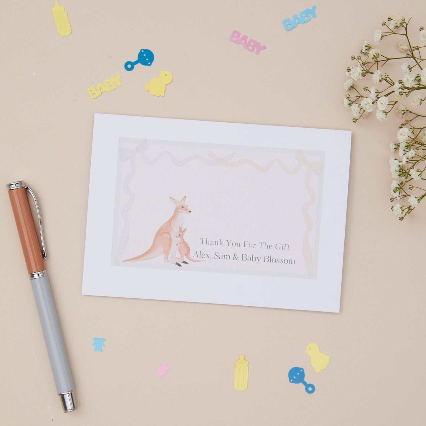 Baby shower thank you card with kangaroo illustration on a beige background with decorative items.