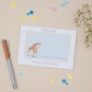 Giraffe and it's young greeting card on a blue background, the card says - thank you for coming to my baby shower - then the mothers name and Bump. The card is set on a neutral background with stationery elements