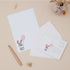 Bunny Rabbit Letter Writing Set with a rabbit illustration and pink balloon on a beige surface with stationery items.