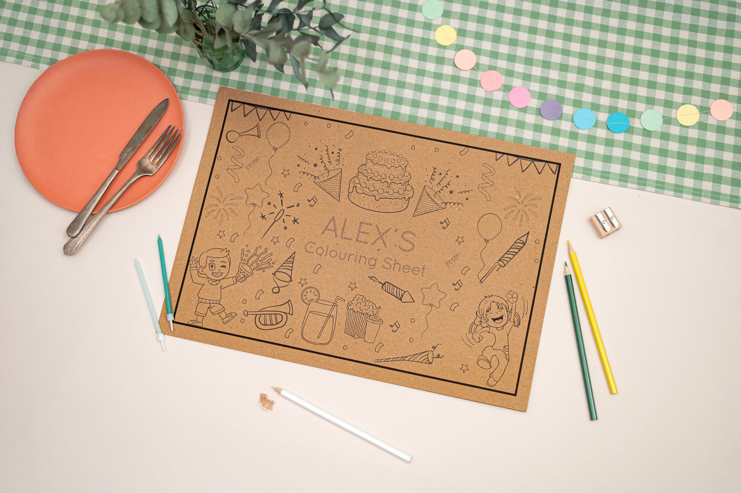 Children's colouring sheet with crayons and a plate on a checkered tablecloth