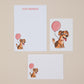 Letter writing set featuring cartoon dogs with pink balloons on a beige background
