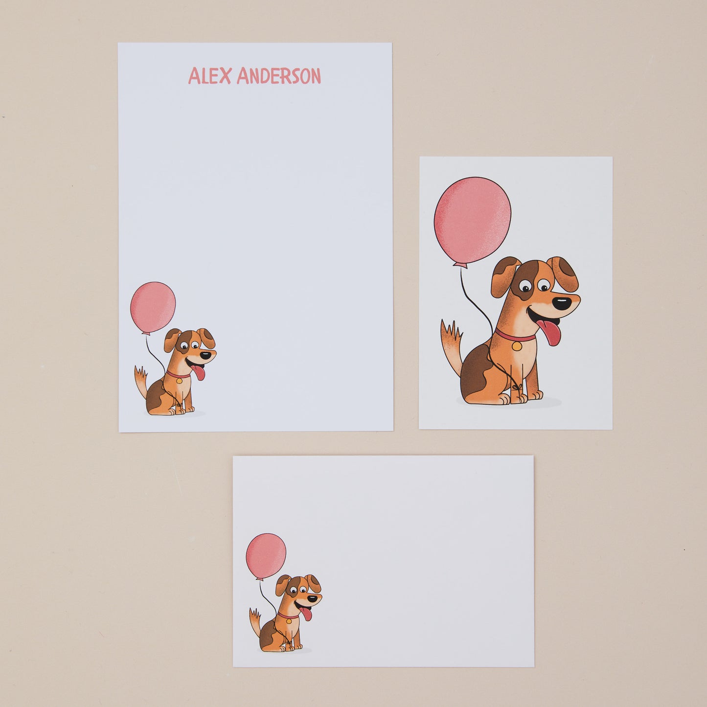 Letter writing set featuring cartoon dogs with pink balloons on a beige background