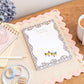 An A5 daily planner with a colorful fox design and a 'Dream Big' motif on the cover, displayed on a wooden desk alongside a cup of tea, notepad, and stationery items.