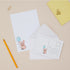 Letter Writing set with Postcards with a cartoon pig holding a blue balloon on a beige surface with a pencil and yellow paper clip.
