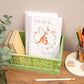 Kangaroo A5 Wirebound Notebook. Handmade notebook with a kangaroo and baby design on the cover, placed on a desk inside a green plastic basket alongside other stationery items.