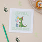 Kids Green Dinosaur Birthday greeting card with an illustration of a dragon holding balloons and a present, with the text 'HAVE A SUPER DAY' on a beige background. A green pencil and decorative elements are also visible.