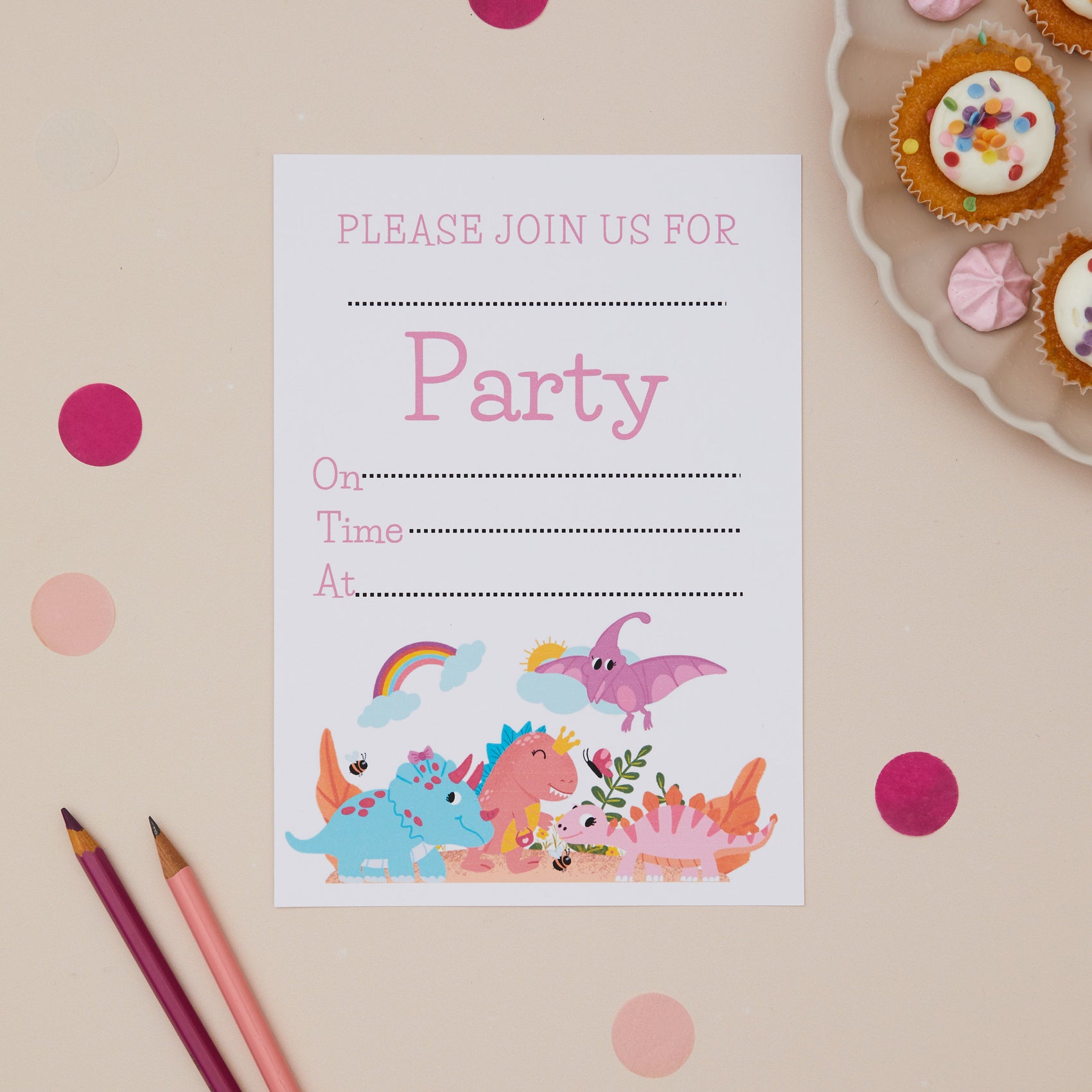 A children's party invitation featuring colorful baby dinosaur illustrations and blank space for party details, placed on a table with confetti and pencils.