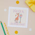 A greeting card with an illustration of a giraffe, surrounded by balloons, with the text &