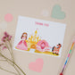 A postcard featuring a princess design with a carriage and horse. In the background there is a pencil and heart-shaped stickers.