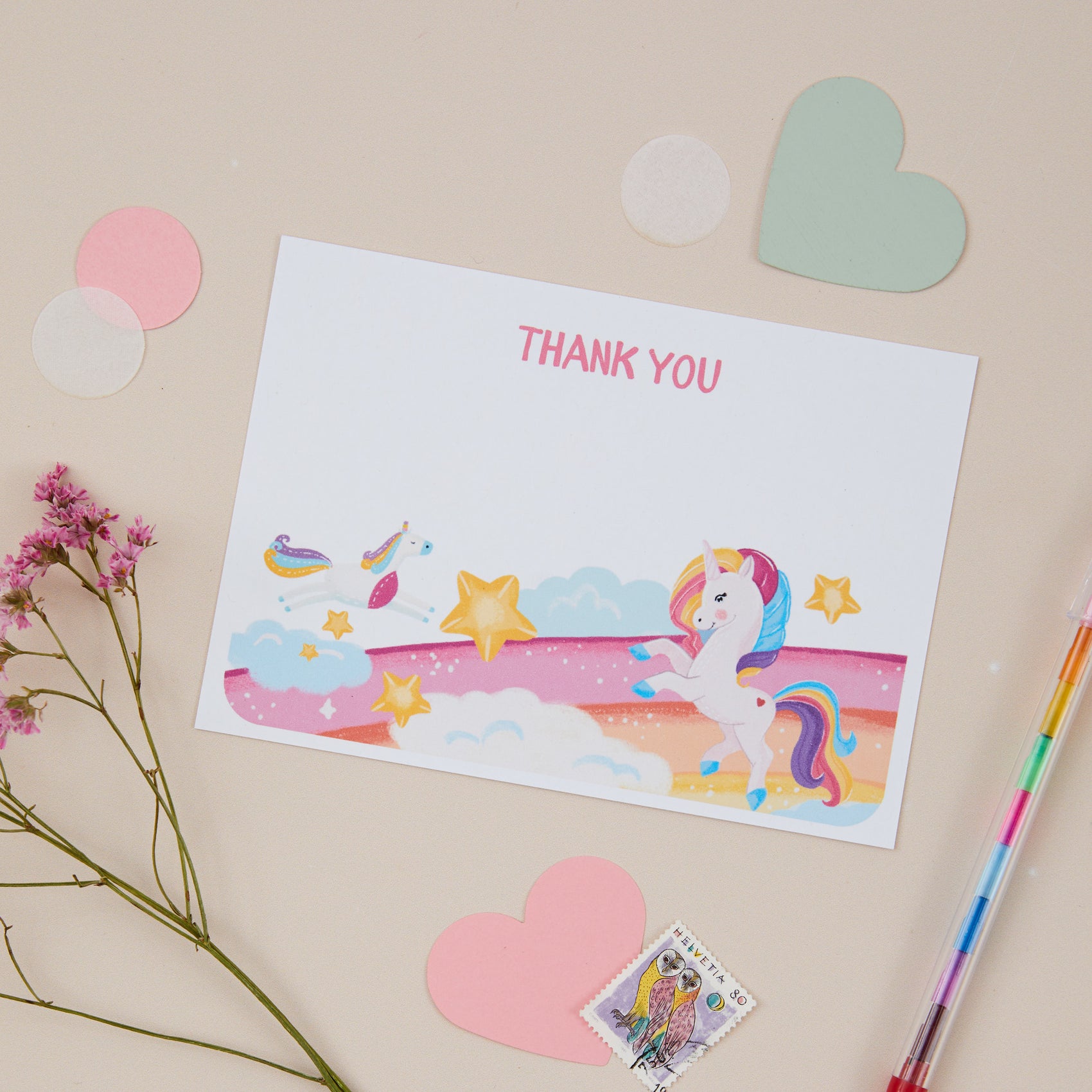 Kids Unicorn Postcard Set. A set of postcards with a unicorn theme, displayed alongside paper confetti, stationery and other decorative elements