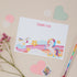 Kids Unicorn Postcard Set. A set of postcards with a unicorn theme, displayed alongside paper confetti, stationery and other decorative elements