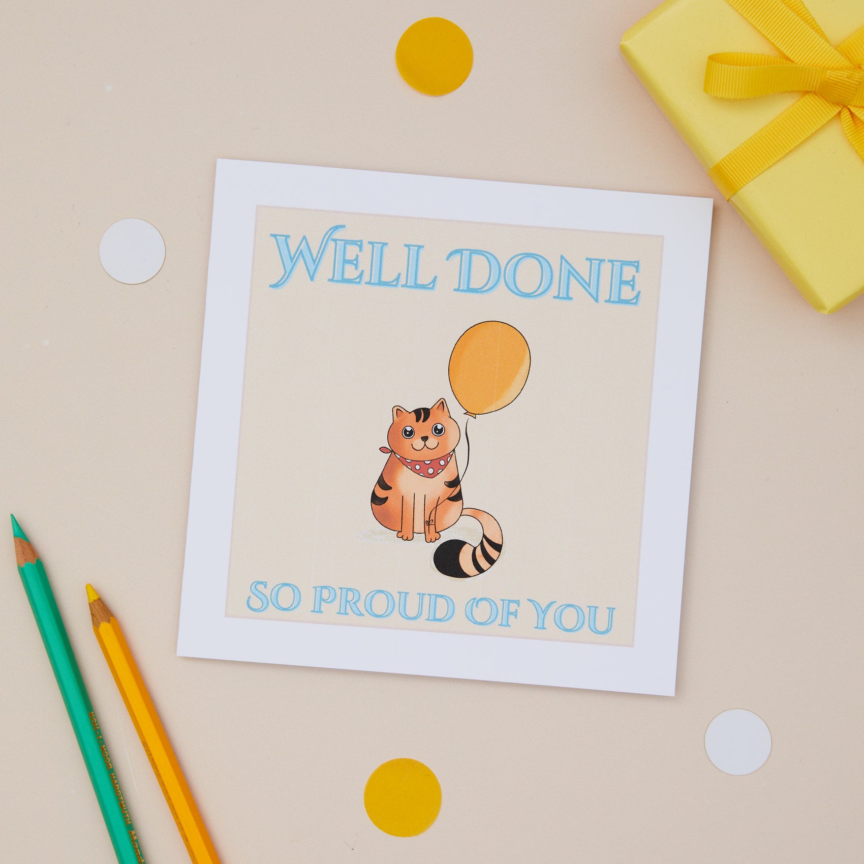 A greeting card with an illustration of a cat holding a balloon, and the text 'Well Done, So Proud of You!' 