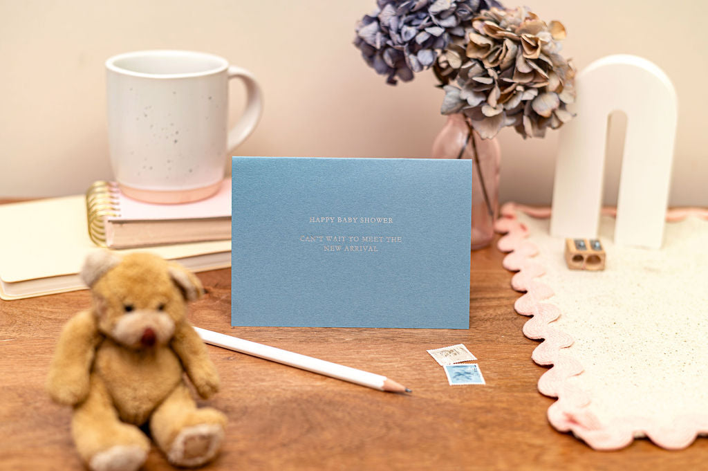 Letterpress Happy Baby Shower Card in Blue with silver font which says happy baby shower, can't wait to meet the new arrival