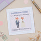 A Mum And Stepdad Happy Anniversary Card with an illustration of a dressed-up fox and a dressed-upMrs. Fox, with a 'Congratulations Happy Anniversary' message.