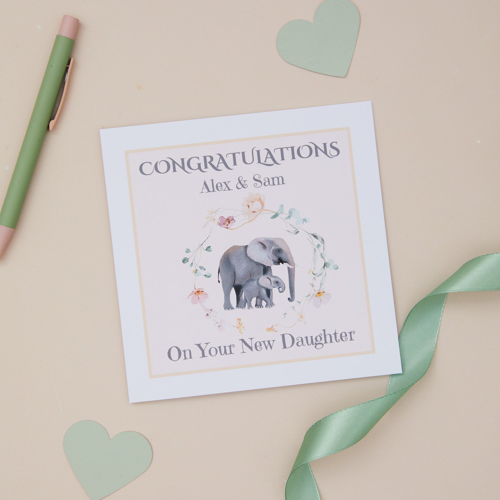 A congratulations card with an illustration of an elephant and a baby daughter, along with the text 'CONGRATULATIONS' and 'Alex & Sam On Your New Daughter'.