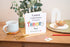 Theory Test Greeting card congratulating on passing theory test, The word theory is spelt out in a patch work type font. The card is placed on a wooden surface with a mug and stationery items.