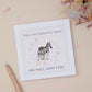 A greeting card with a zebra and its young, surrounded by floral elements, with text that reads 'Enjoy Your Maternity Leave - WE WILL MISS YOU'. There's a pen and pink decorative items at the bottom.