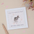 A greeting card with a zebra and its young, surrounded by floral elements, with text that reads &